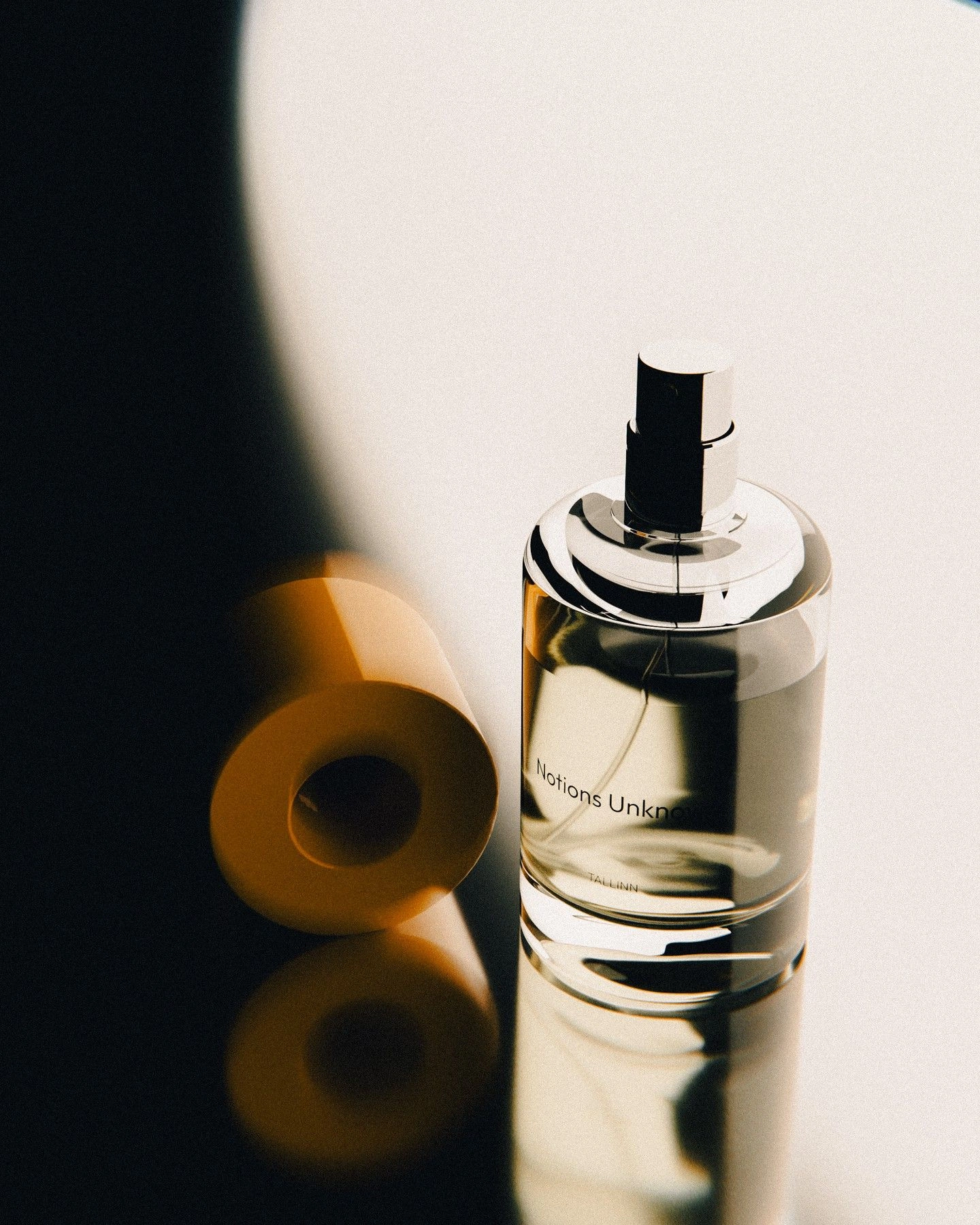 Frasco de perfume Notions Unknown sob luz e sombra